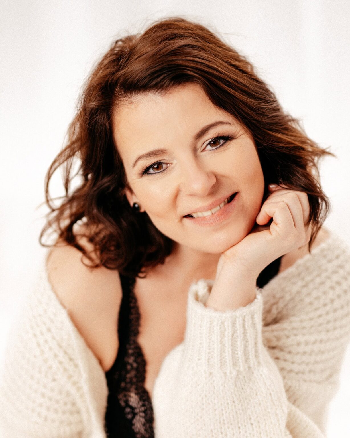 Lächelnde Frau in Boudoir-Fotoshooting, natürliche Schönheit und Selbstvertrauen.